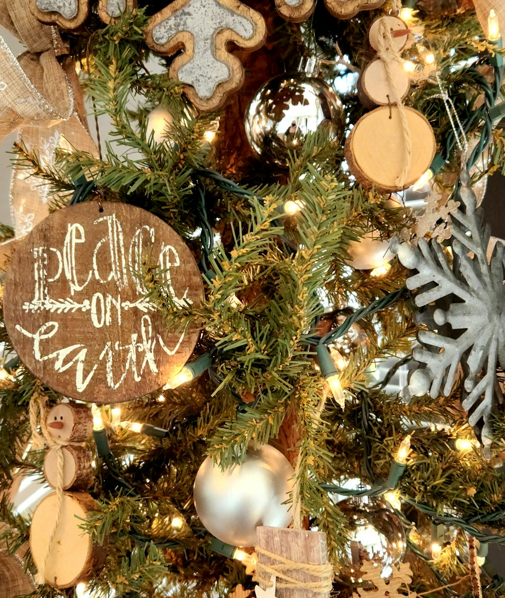 a christmas tree with ornaments and a wooden sign
