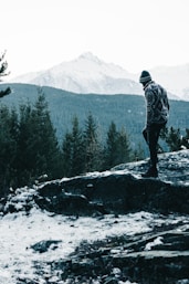 a man standing on top of a snow covered mountain