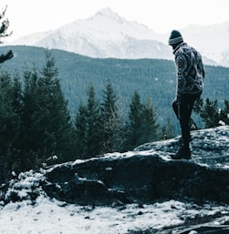 a man standing on top of a snow covered mountain