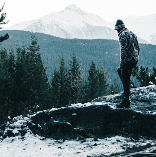 a man standing on top of a snow covered mountain