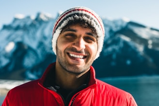 A portrait of me smiling outdoors, wearing a red jacket that reflects my Canadian roots.