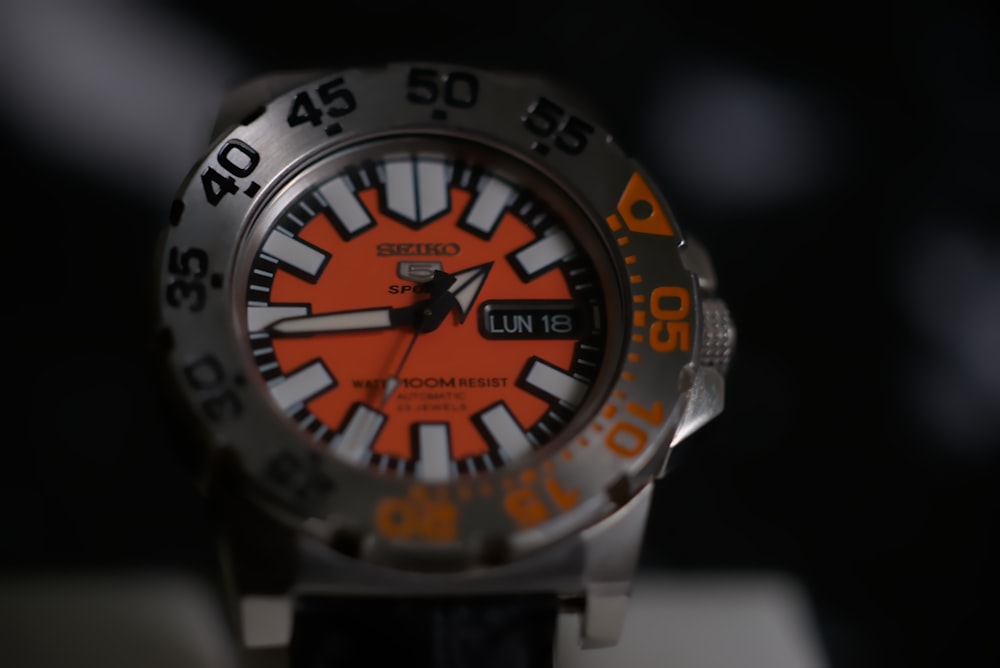 a watch with an orange and black dial