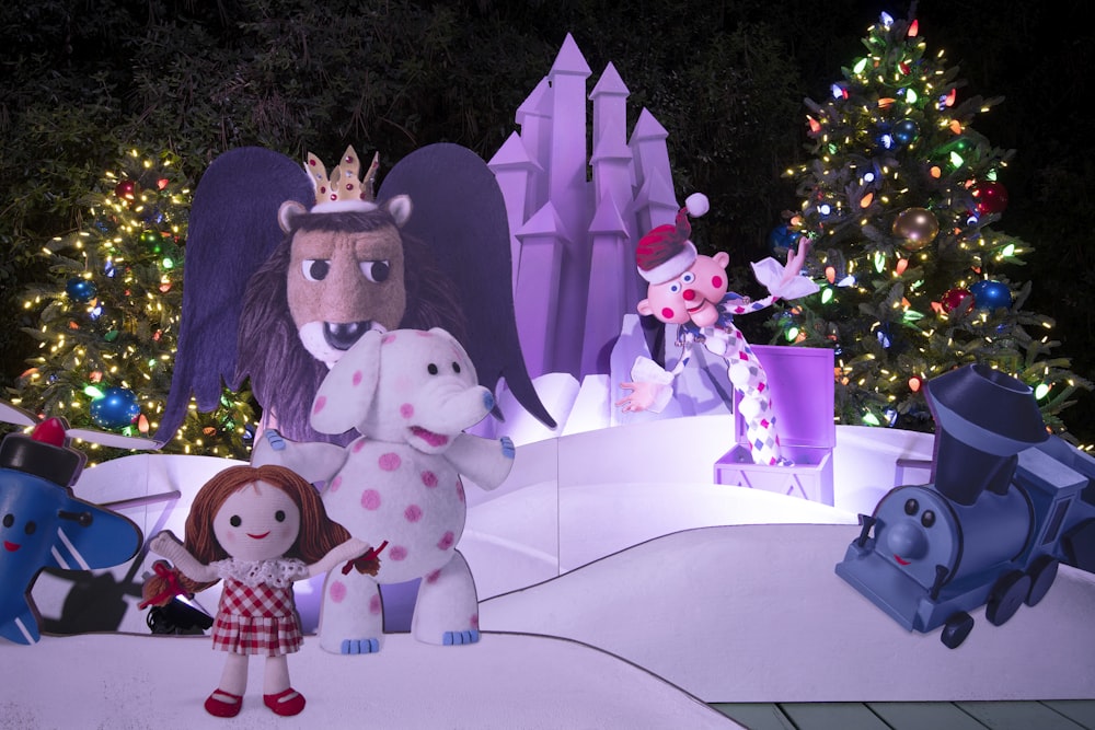 a group of stuffed animals standing in front of a christmas tree