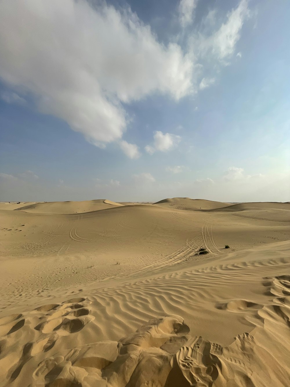 a sandy area with a few clouds in the sky