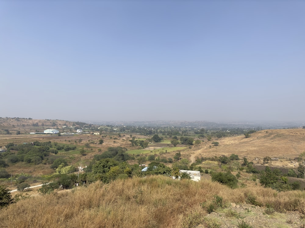 a view of a valley with a few houses in the distance