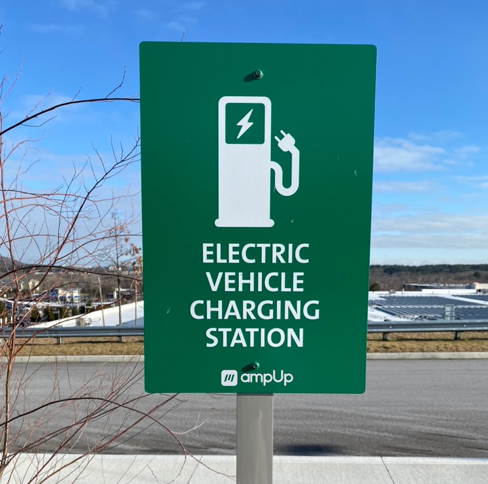 a green sign that says electric vehicle charging station