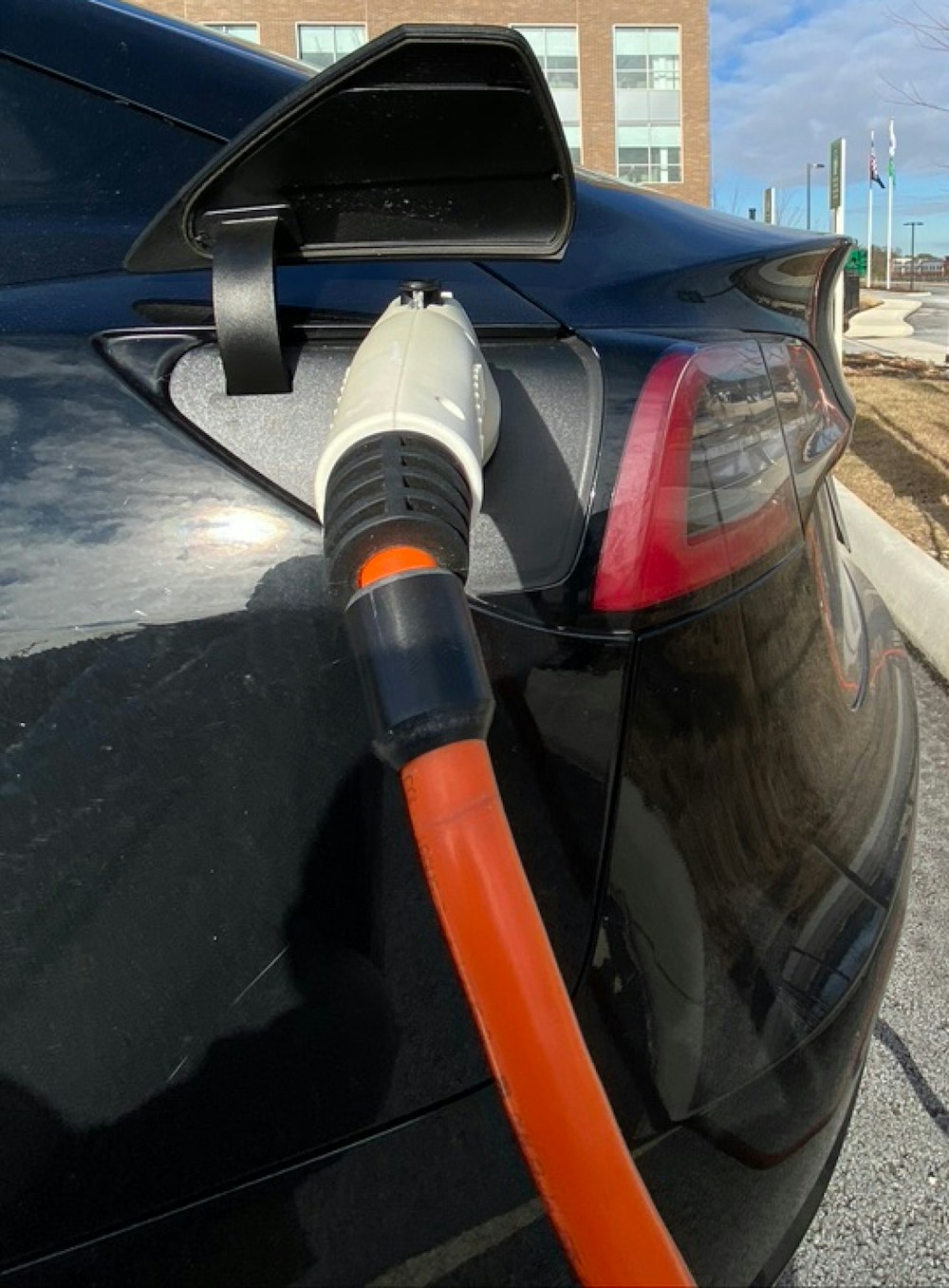 Un coche negro con una manguera naranja unida a él