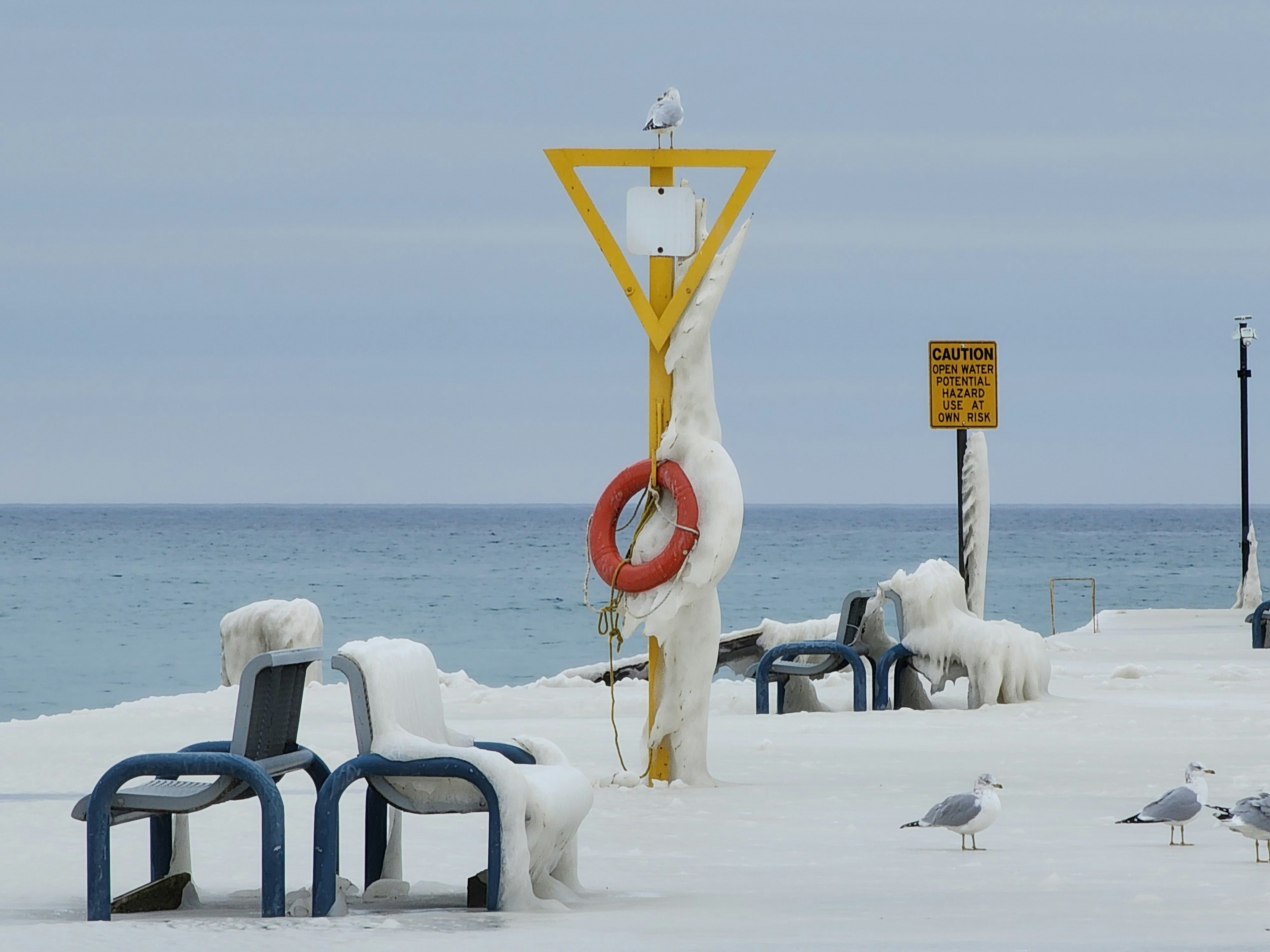 a couple of benches sitting on top of snow covered ground