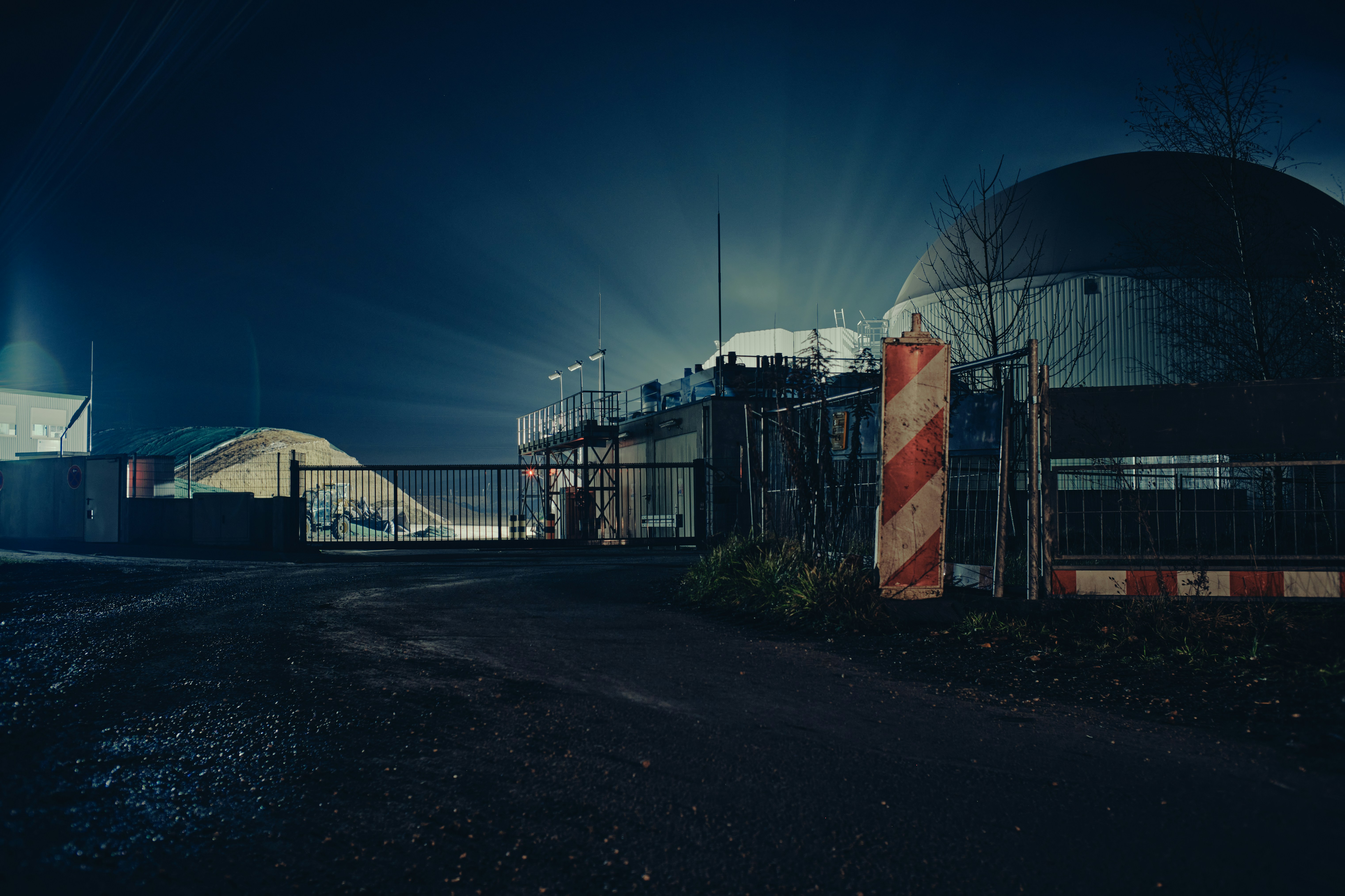 une zone clôturée à côté d’un bâtiment la nuit