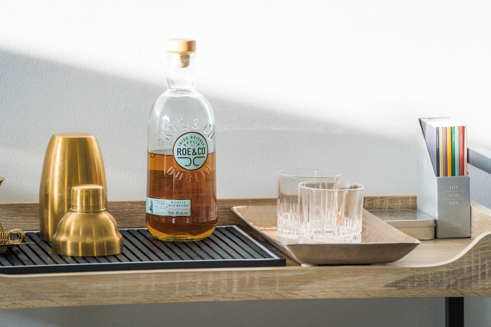 a bottle of alcohol sitting on top of a wooden tray