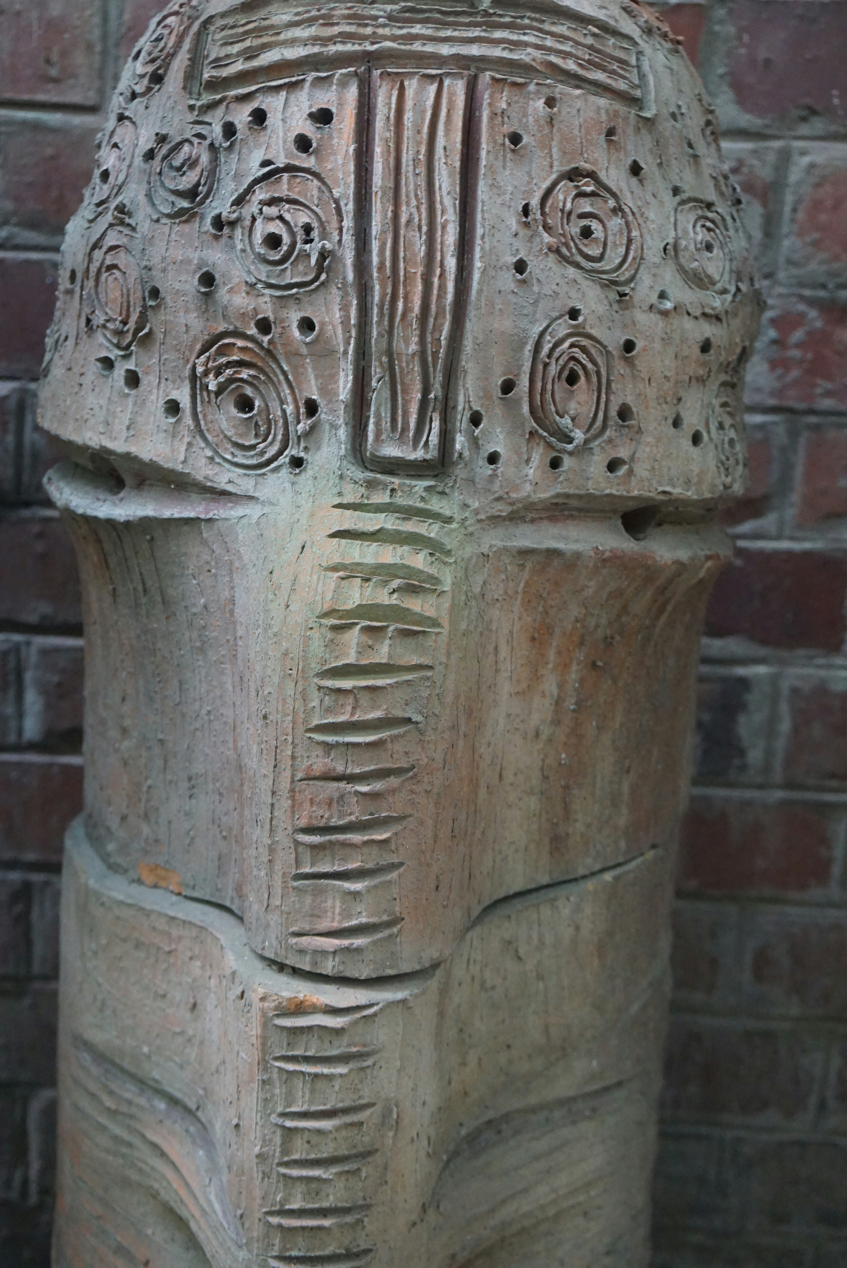 a close up of a statue near a brick wall