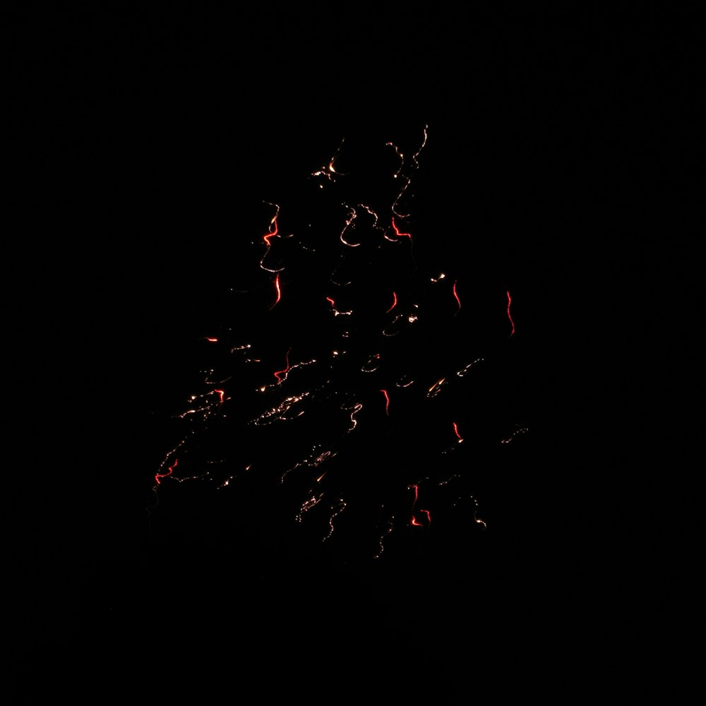 un fond noir avec un tas de feux d’artifice rouges