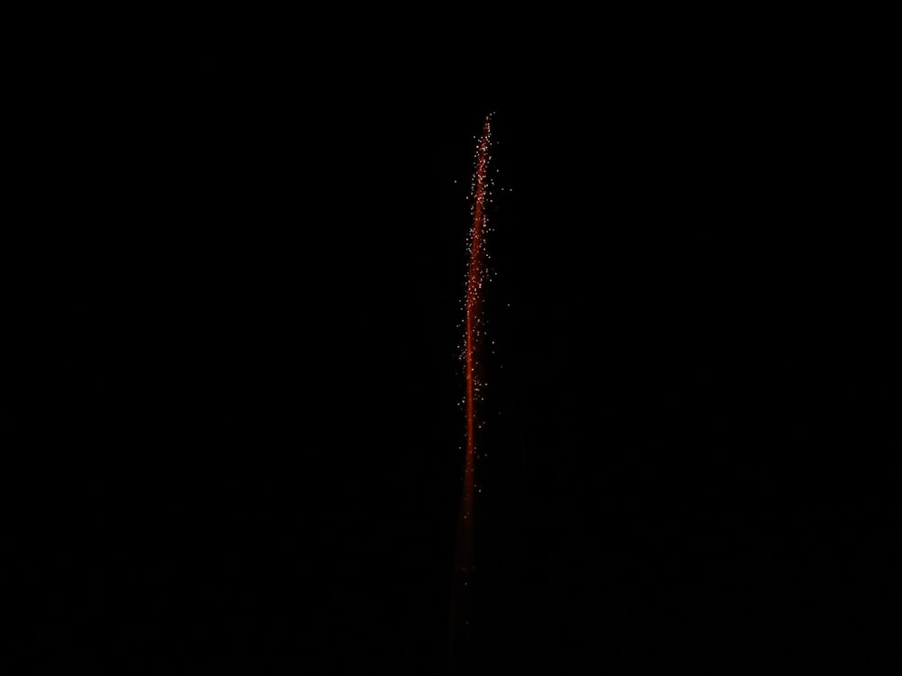 a red and white fire hydrant in the dark