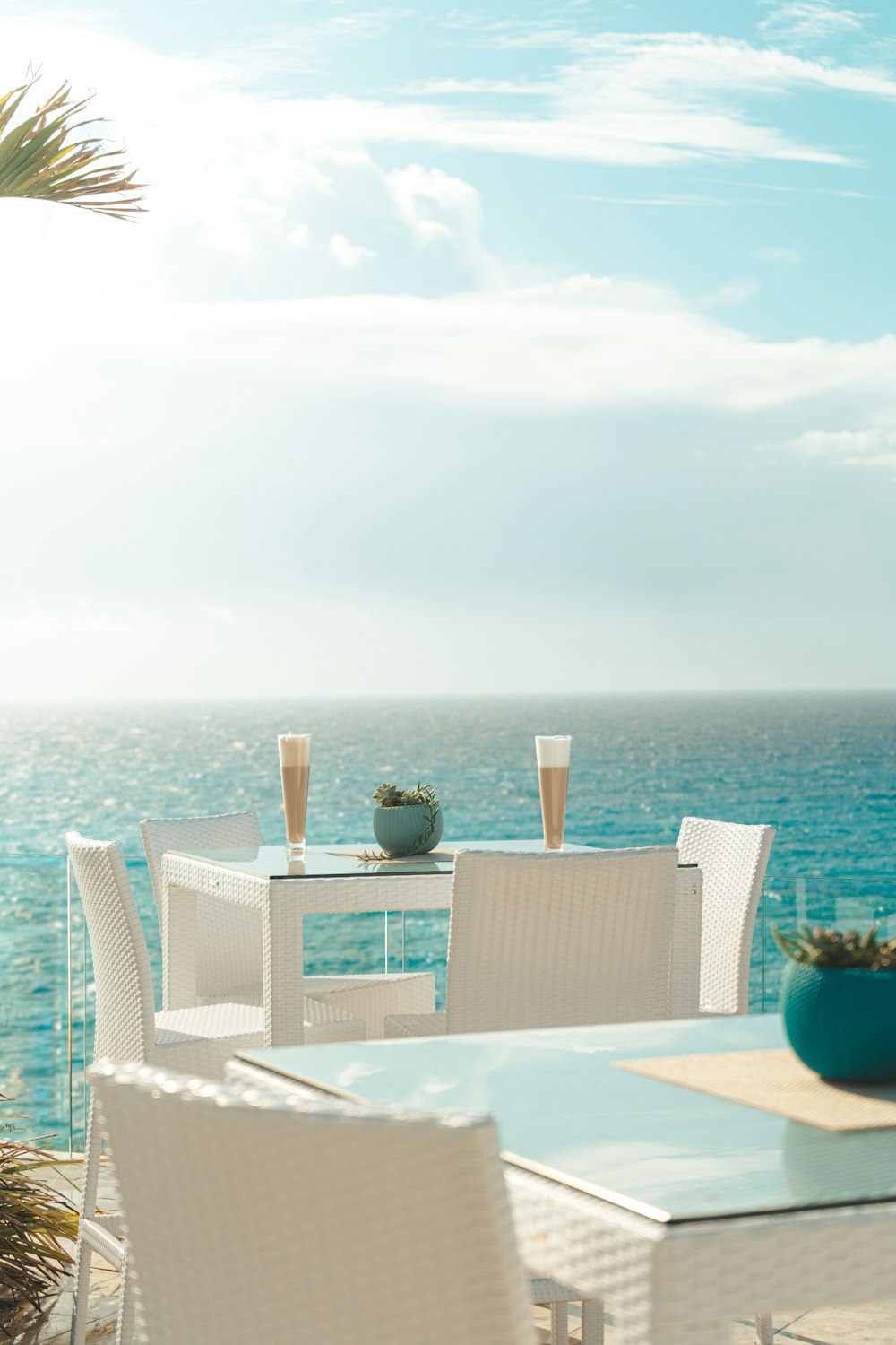 a table and chairs on a patio overlooking the ocean