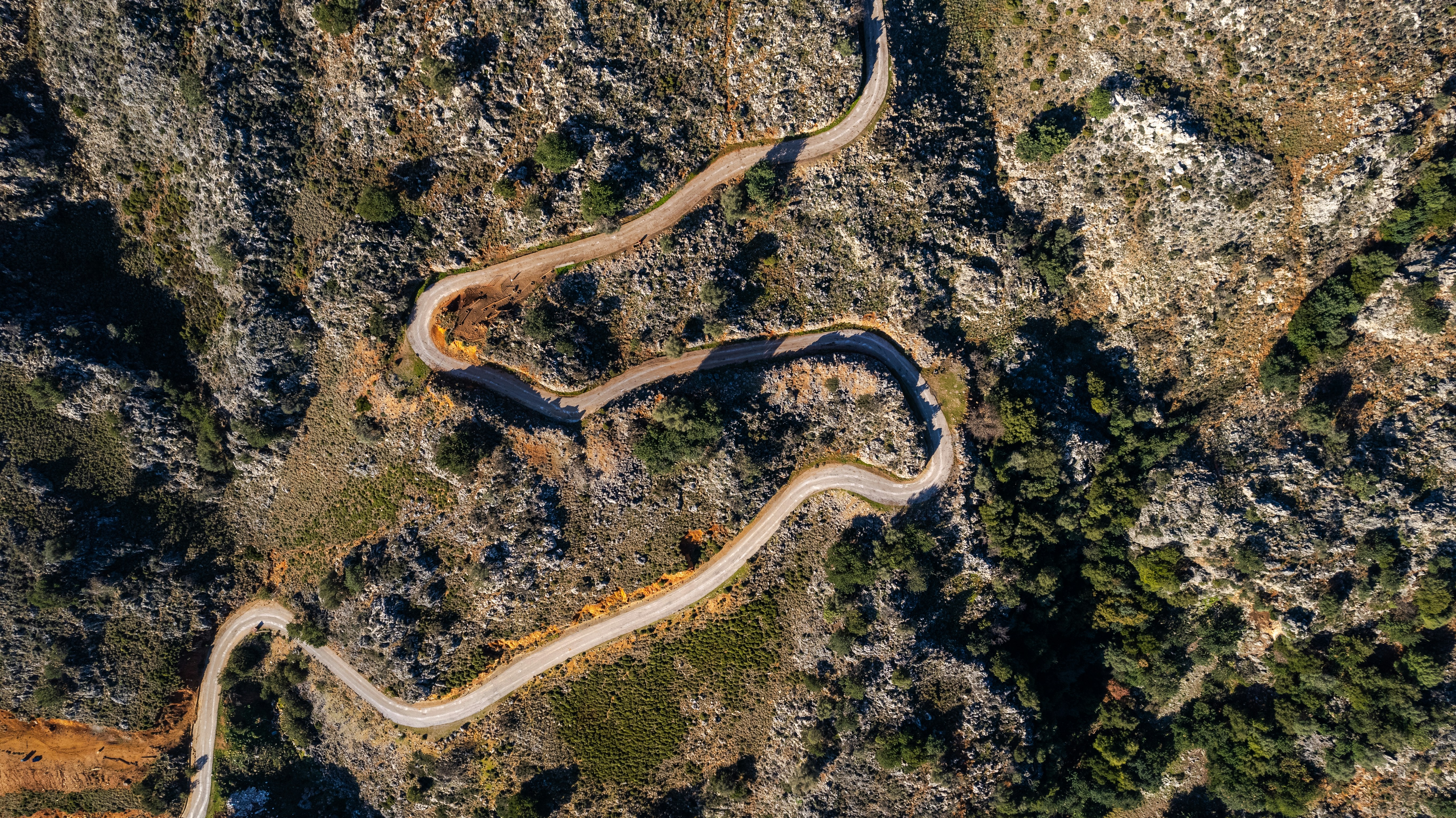 an aerial view of a winding road in the mountains