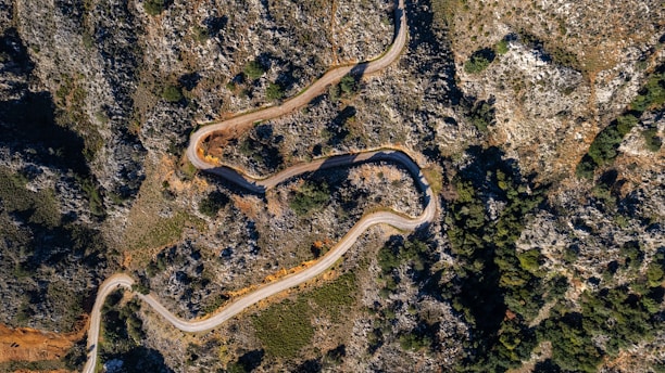an aerial view of a winding road in the mountains