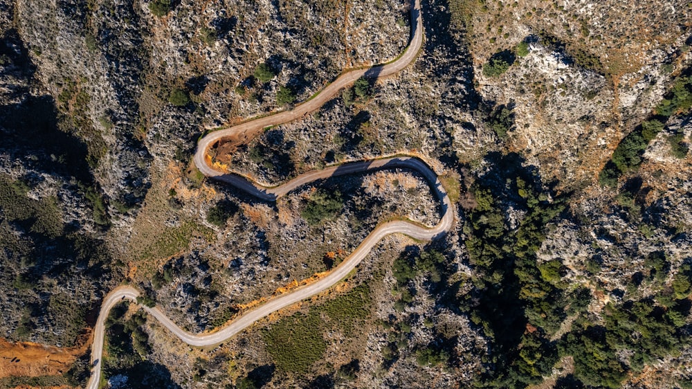 an aerial view of a winding road in the mountains