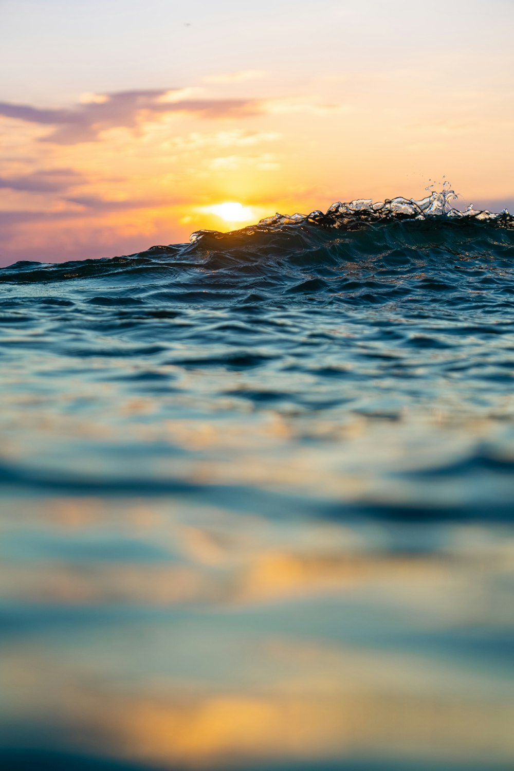 the sun is setting over the ocean waves