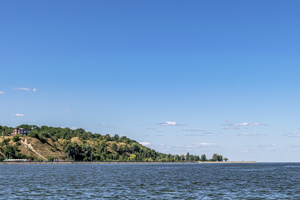 a large body of water with a hill in the background