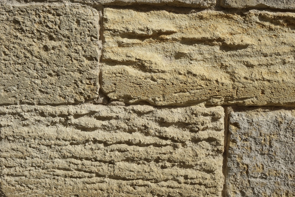 a close up of a stone wall with cracks in it
