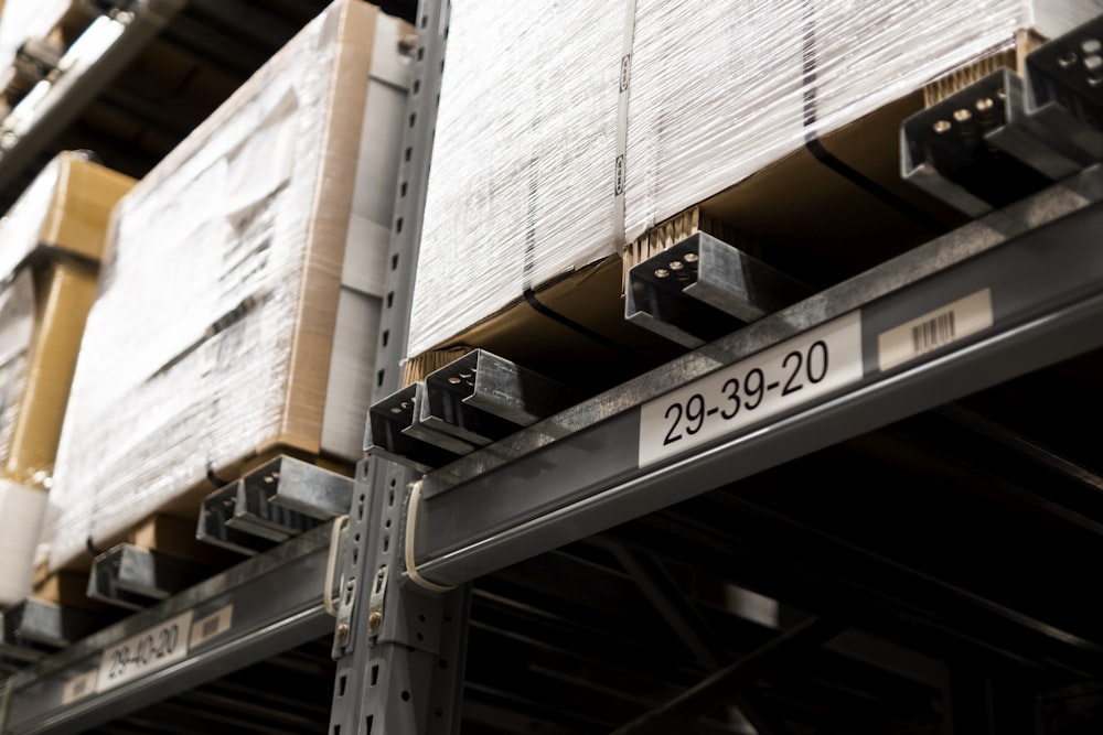 a close up of a metal shelf with boxes on it