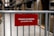 A red sign attached to a metal barrier indicates a restricted area for coworkers only. The background features shelves and boxes, suggesting a warehouse or storage environment.