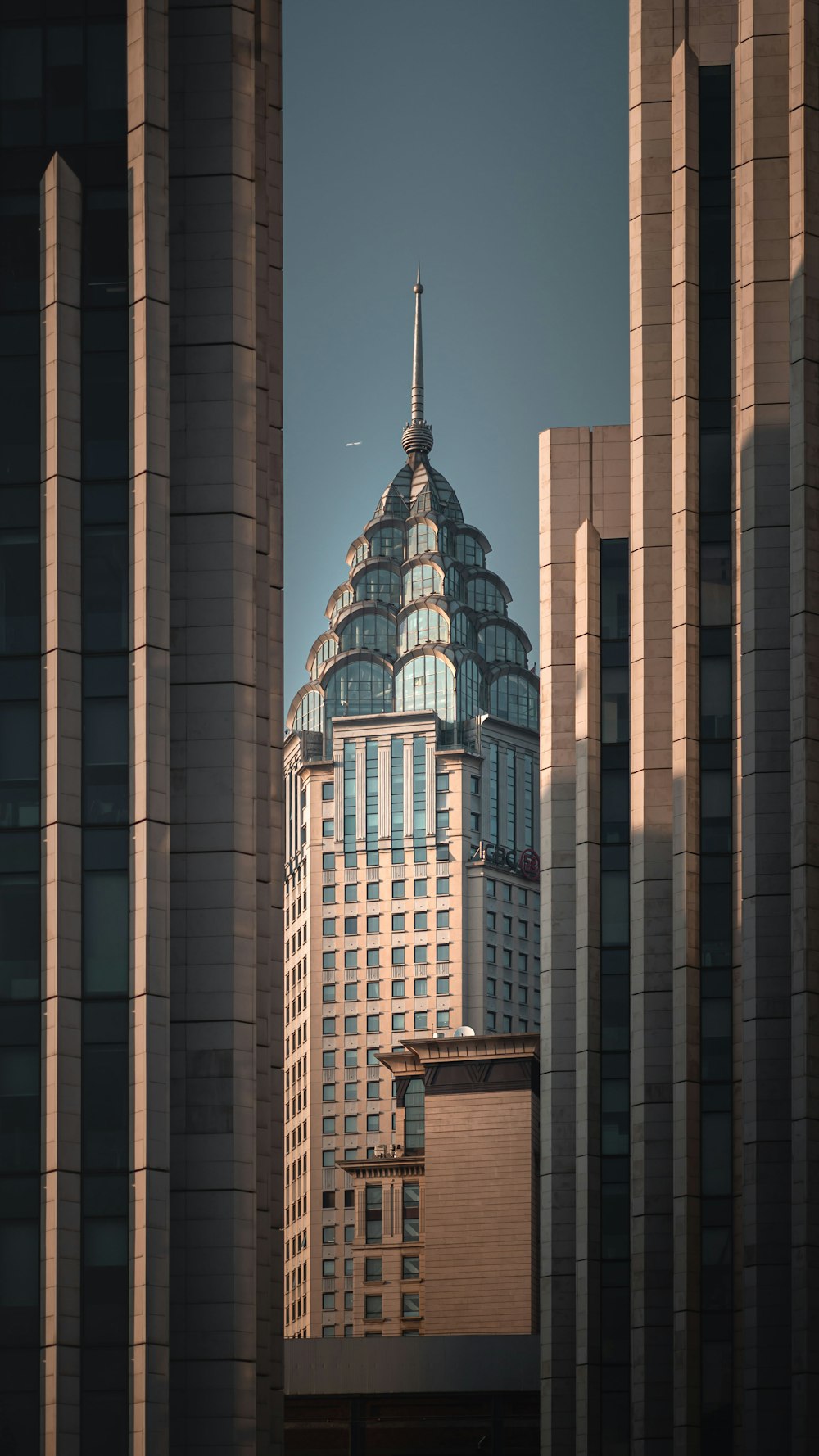 Un edificio alto con una aguja en medio de una ciudad