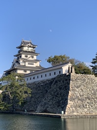 A samurai castle courtyard at twilight, with Miki standing strong and contemplative, dressed in traditional robes.