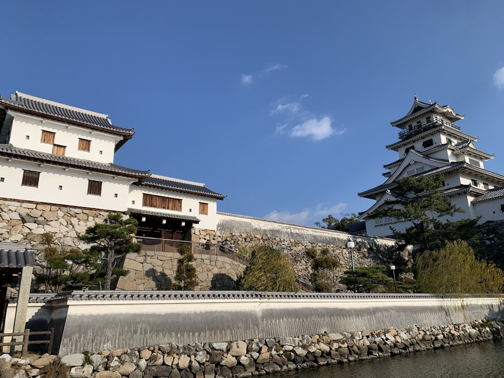 a building with a tower on top of it next to a body of water