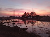 Evening scene of a construction site with workers packing up surveying instruments.
