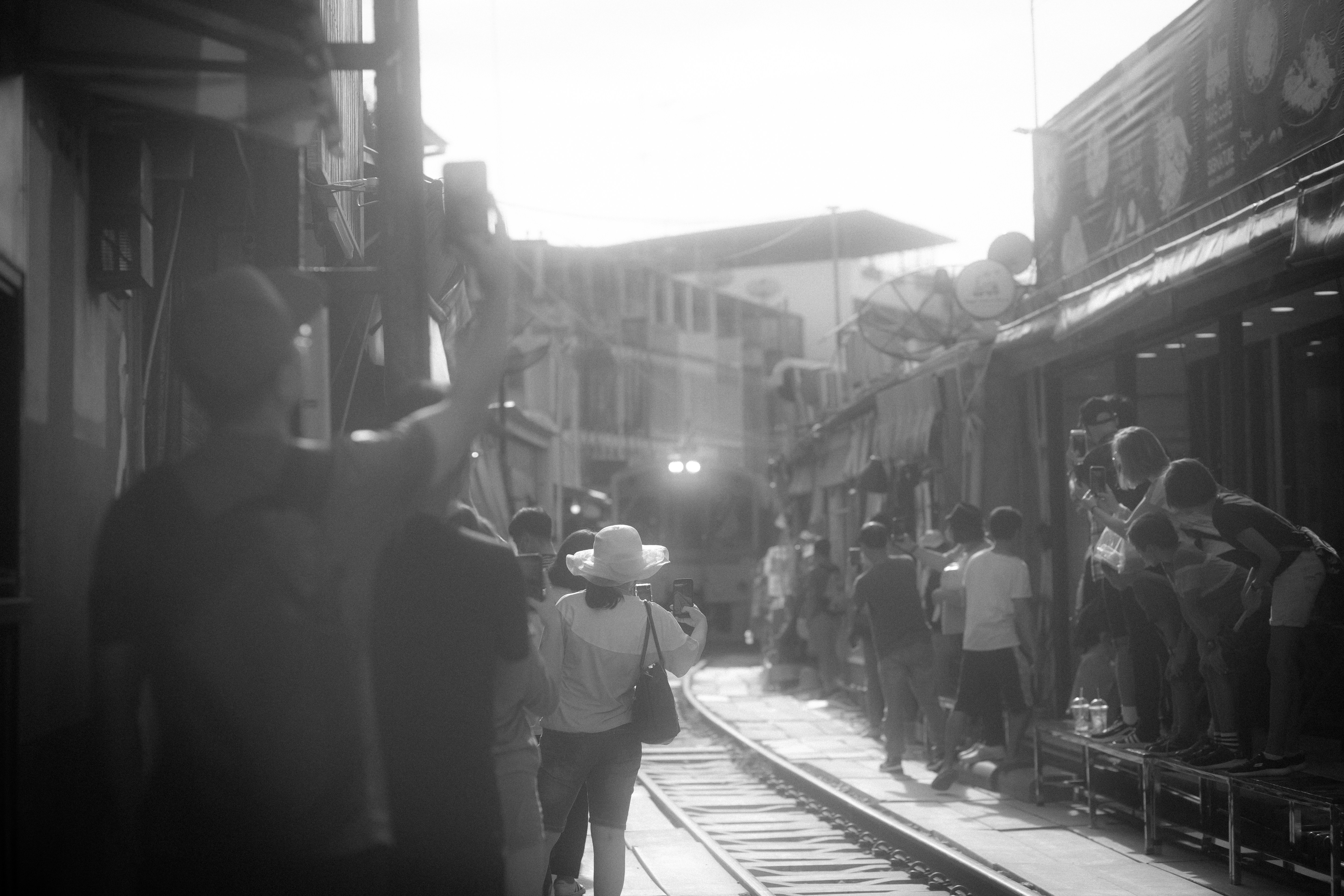a group of people standing on a train track, 