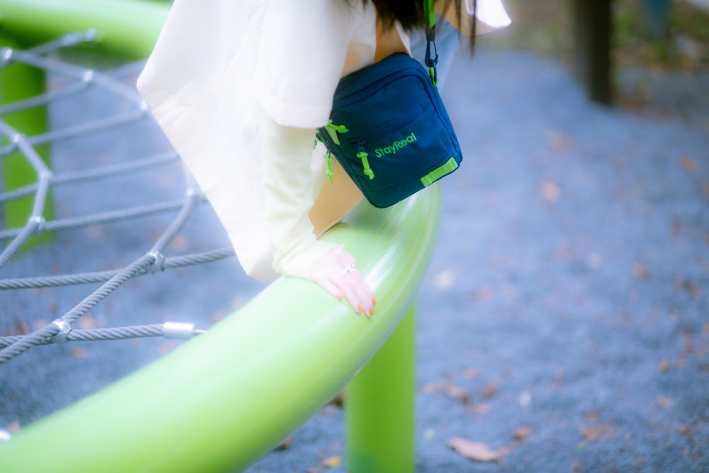 a girl is standing on a green bench