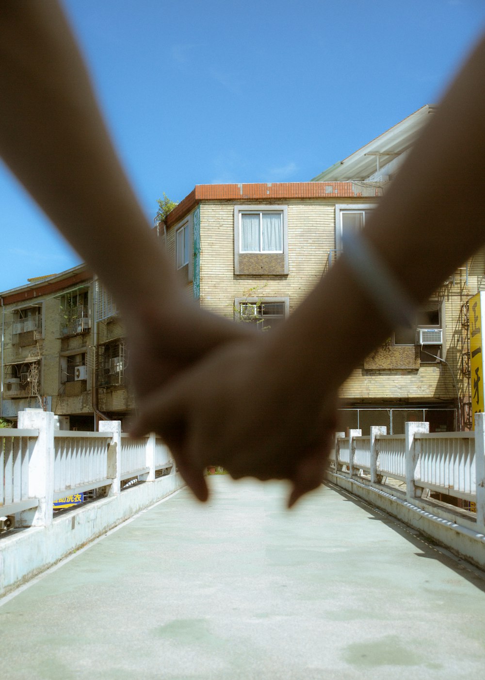 two hands holding each other in front of a building
