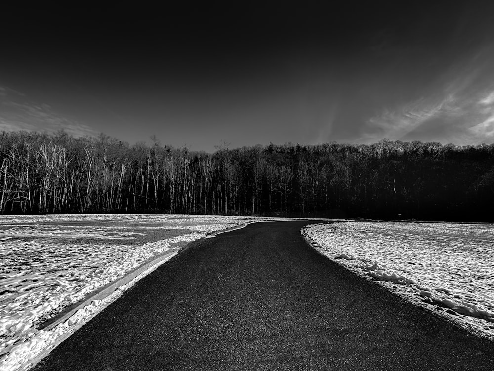 Une photo en noir et blanc d’une route enneigée