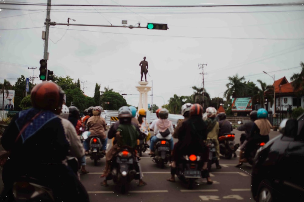 a group of people riding motorcycles down a street