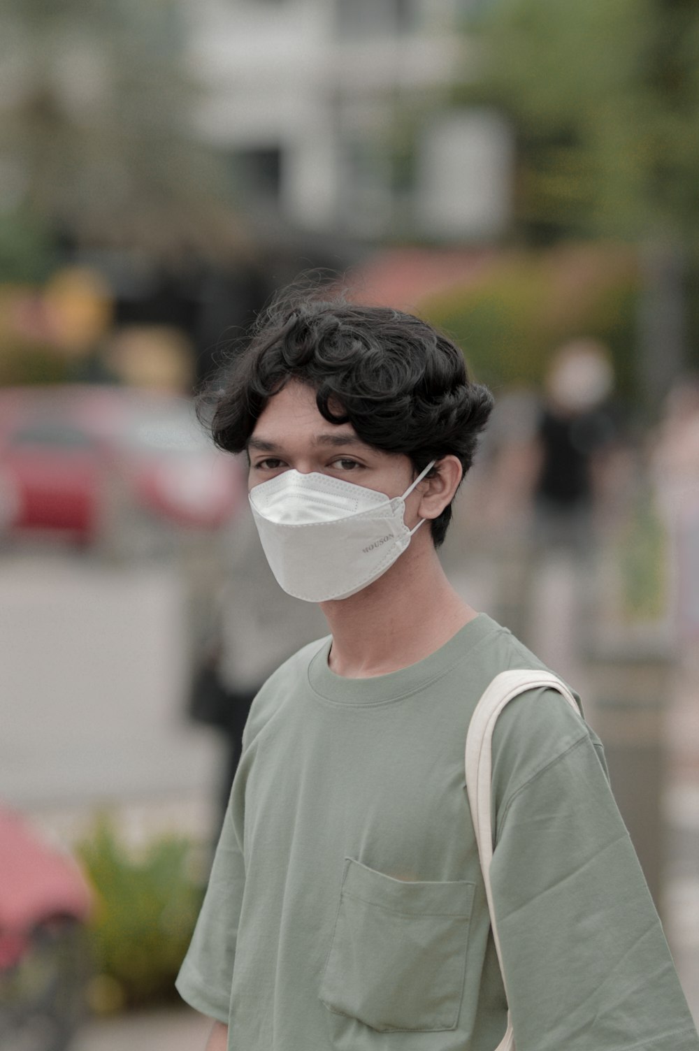a man wearing a face mask walking down the street