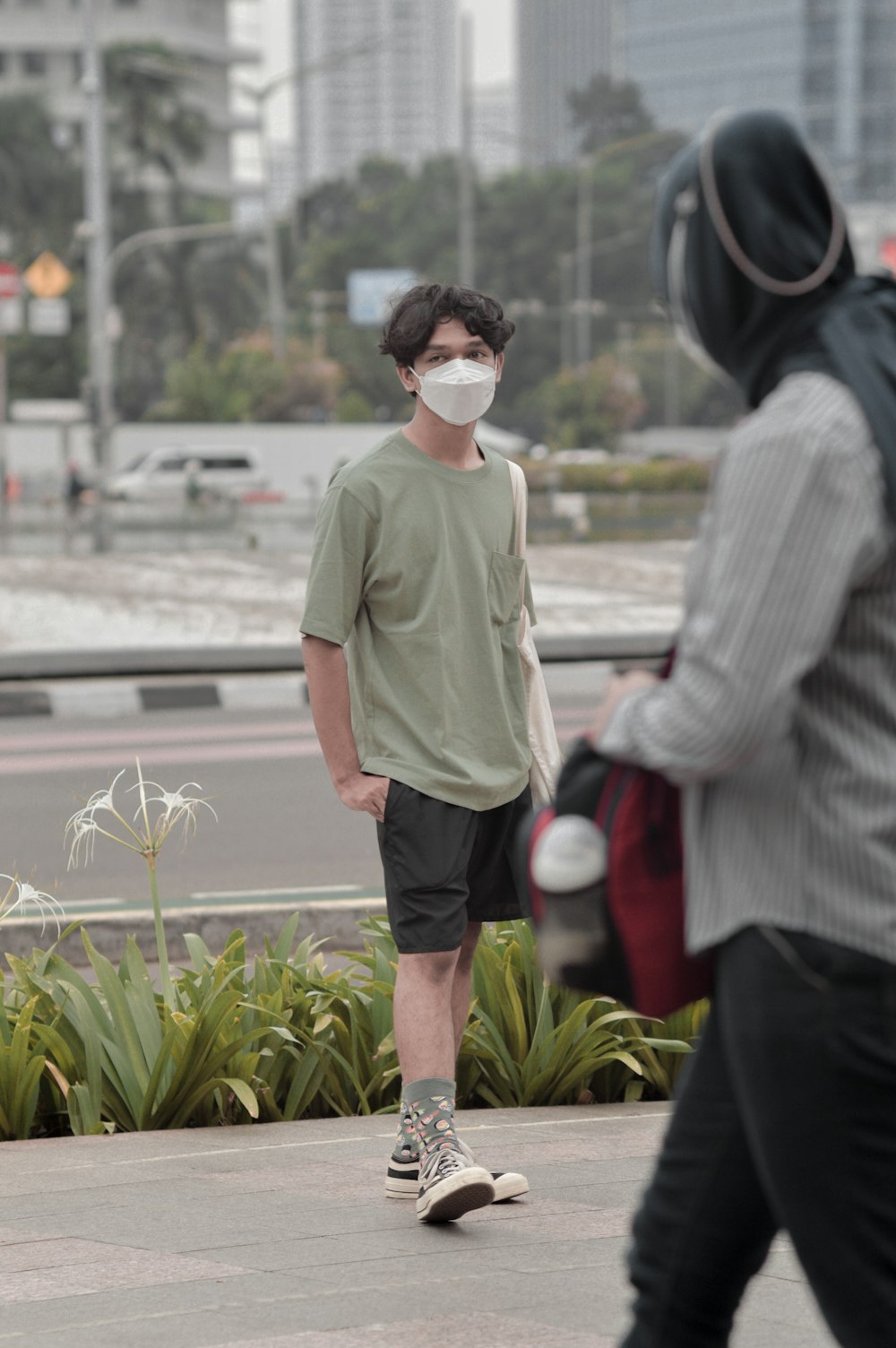 a man wearing a face mask walking down the street