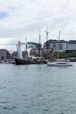 Spacious catamaran docked at a vibrant marina with people preparing for a cruise