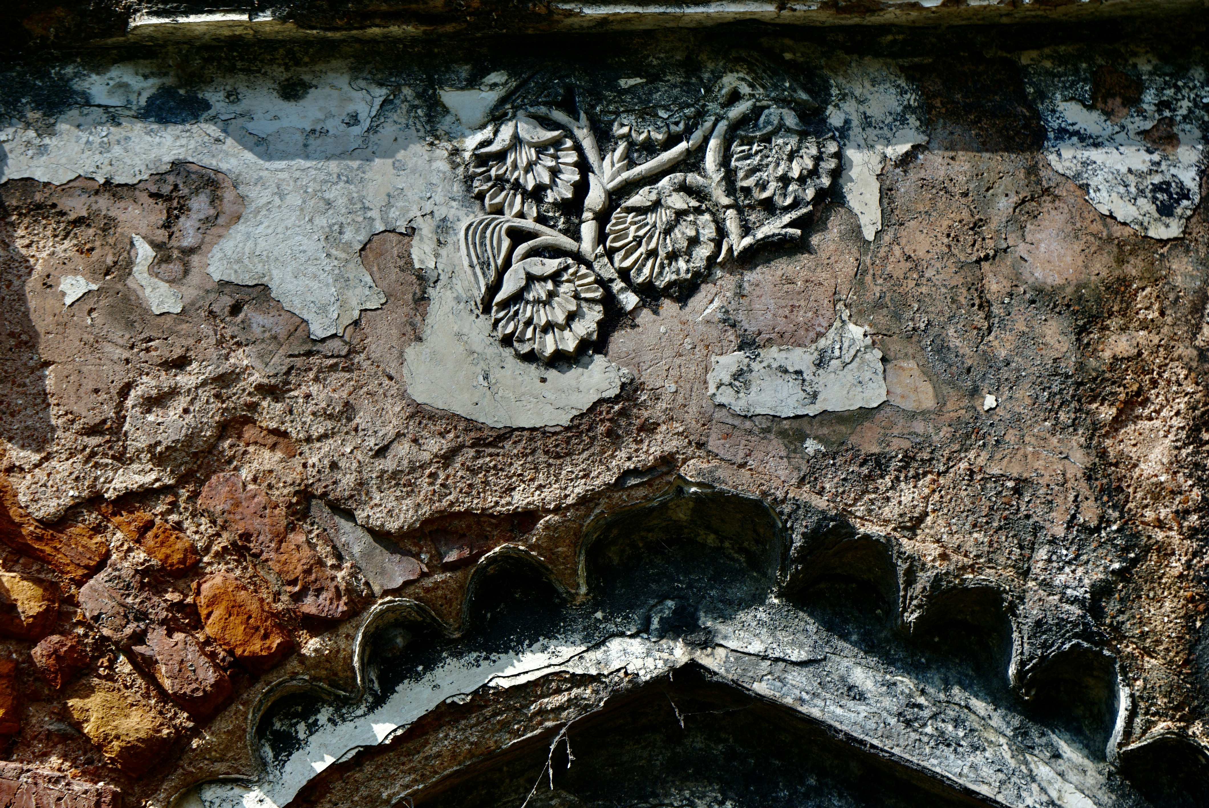 un primo piano di un muro di pietra con una scultura su di esso