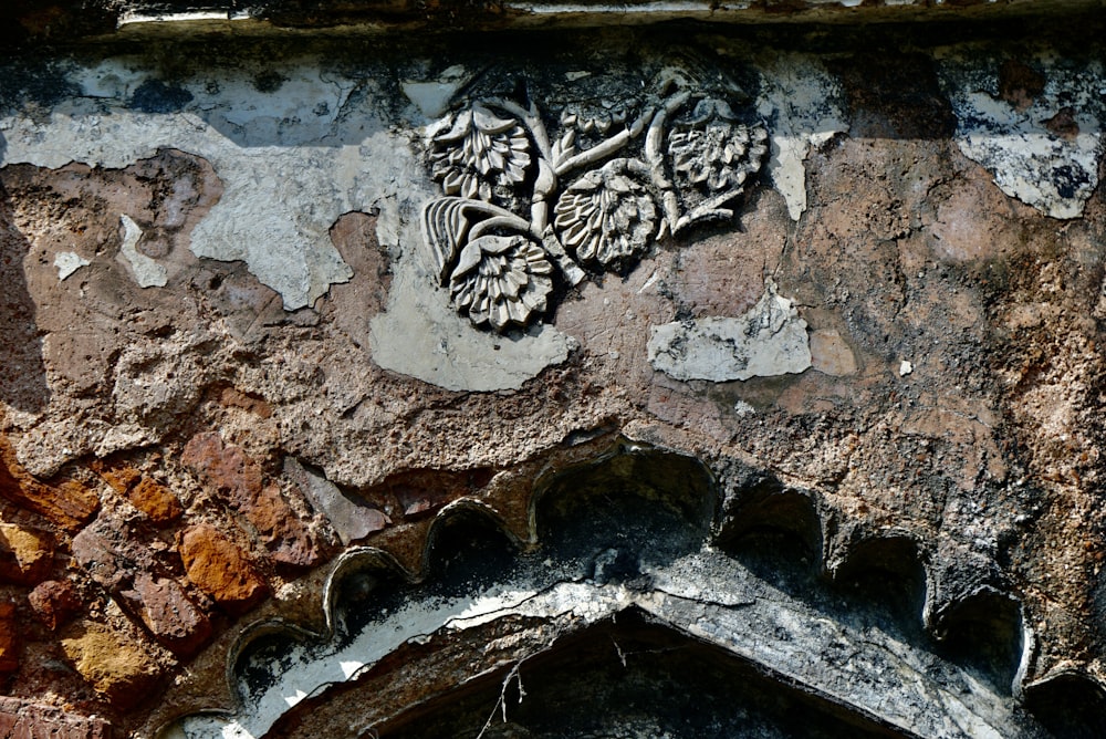 a close up of a stone wall with a carving on it