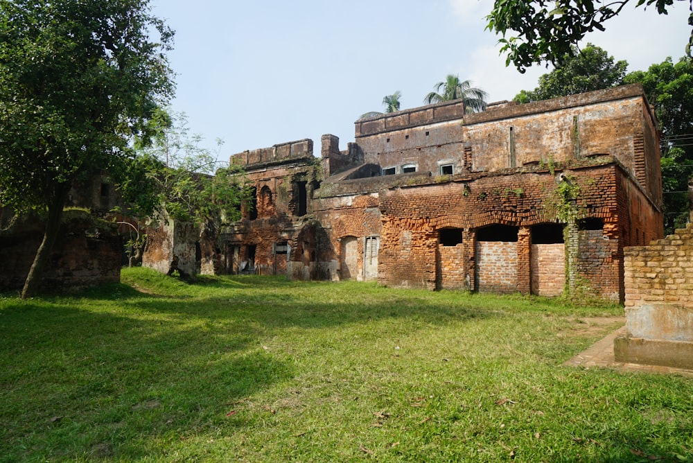 an old building with a lot of windows in the grass