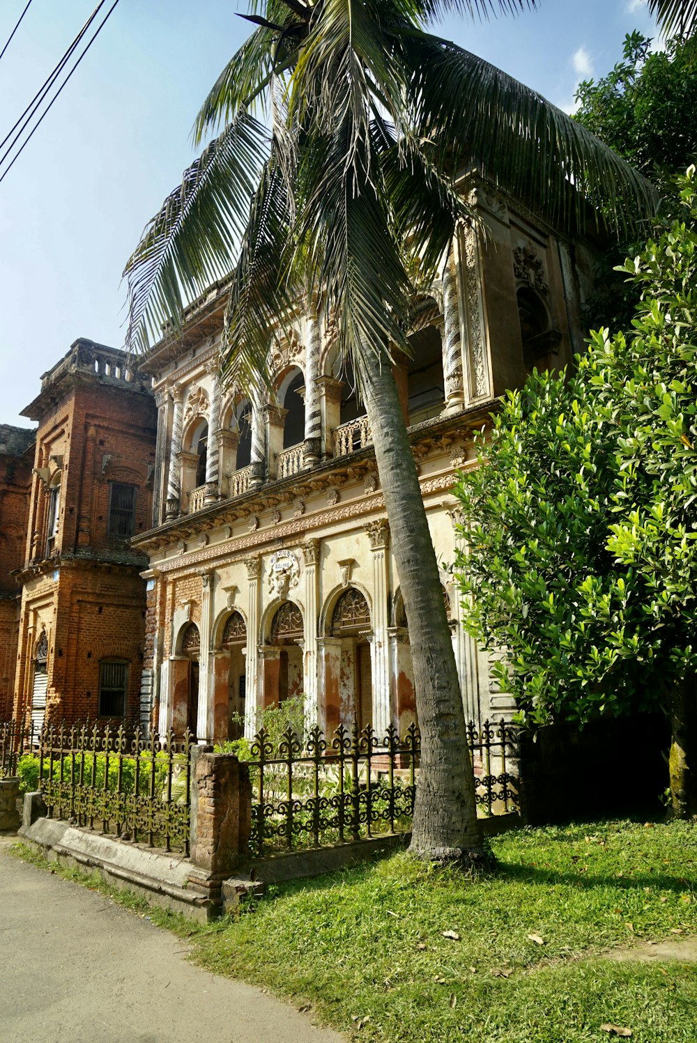 an old building with a palm tree in front of it