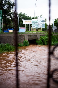a flooded street with a bridge in the background