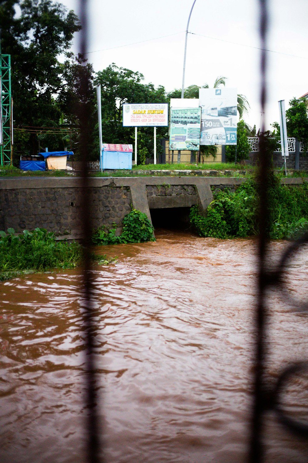 a flooded street with a bridge in the background