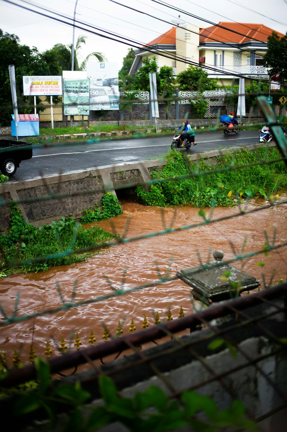 a view of a flooded street through a fence