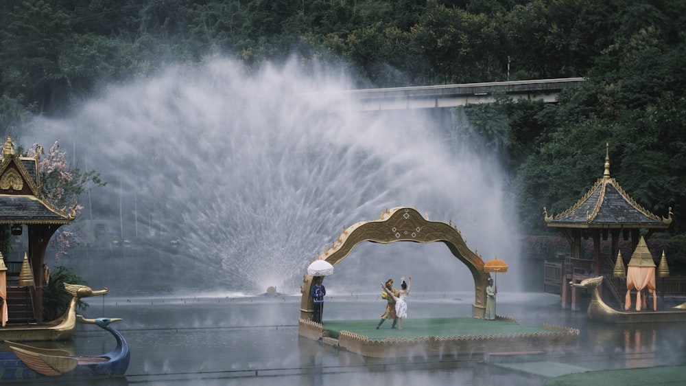 a couple of people that are standing in front of a fountain