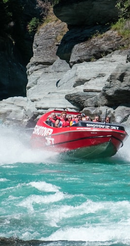 a group of people riding on the back of a red boat