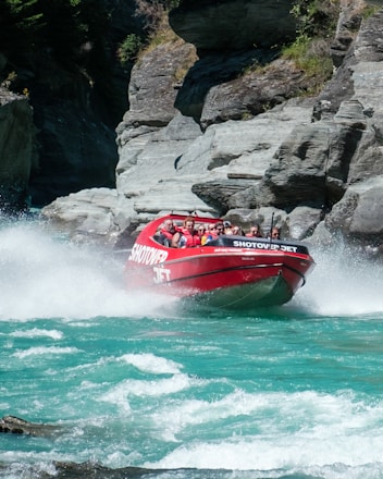 a group of people riding on the back of a red boat