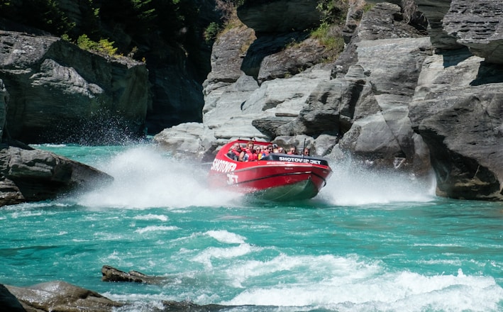 a group of people riding on the back of a red boat