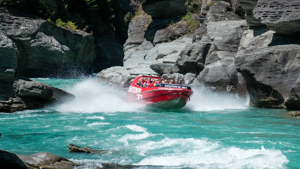 a group of people riding on the back of a red boat